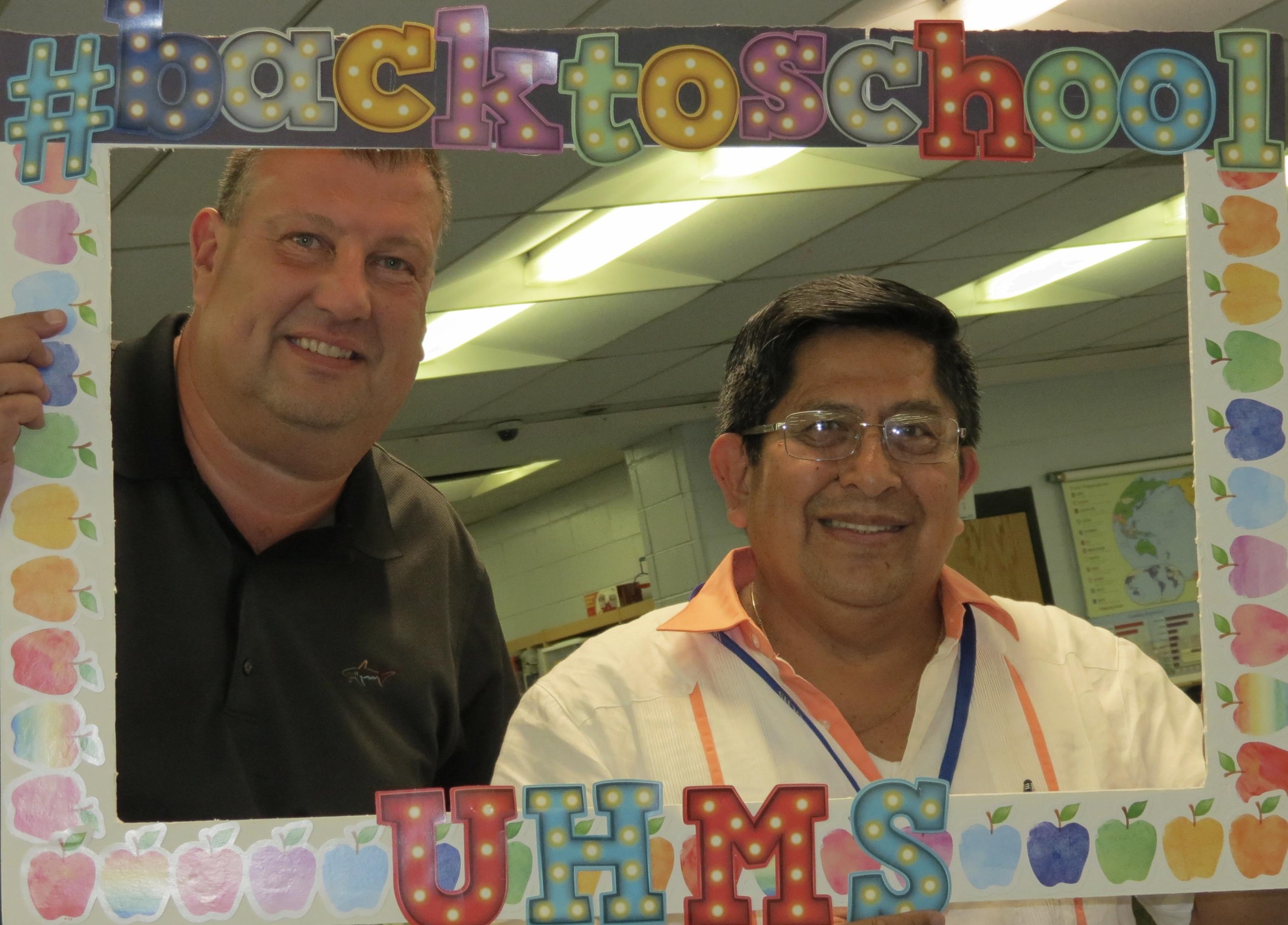 two male teachers with a back to school photo board