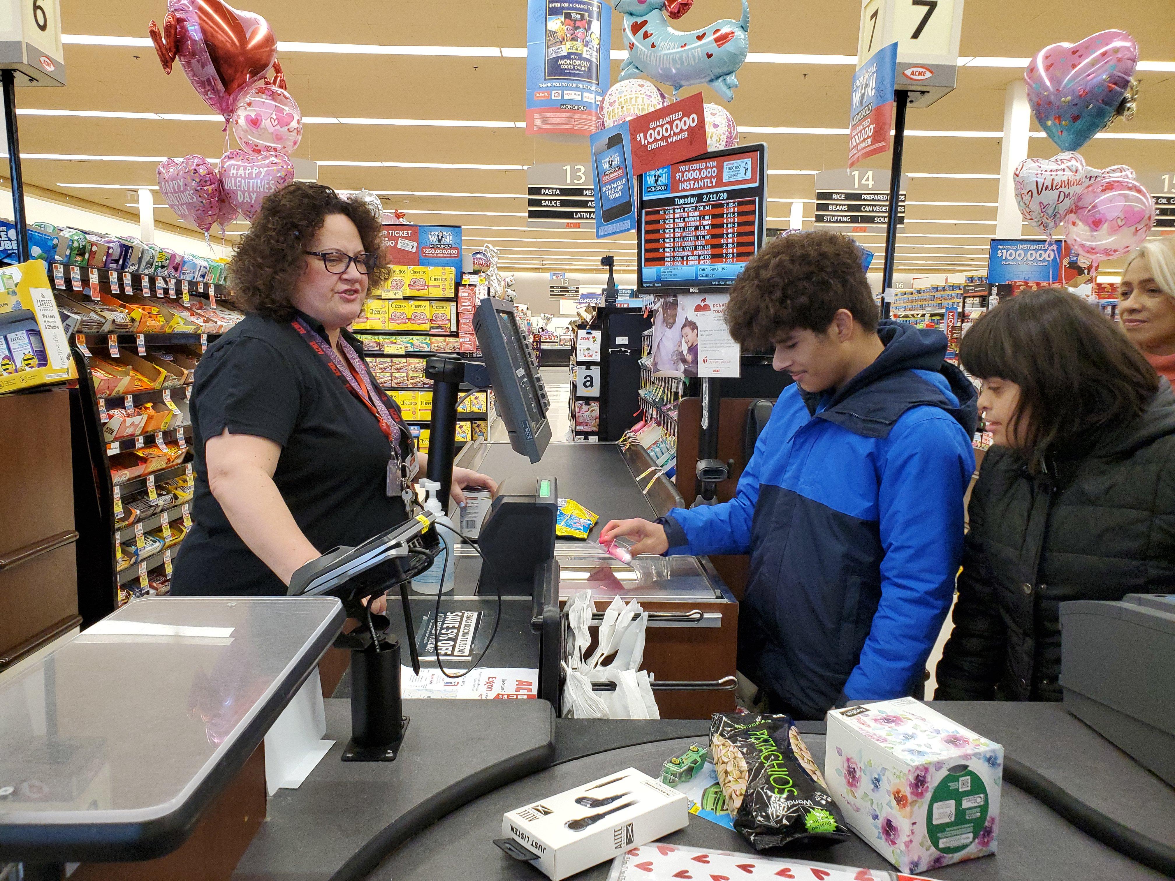 boy practicing to be a cashier at ACME